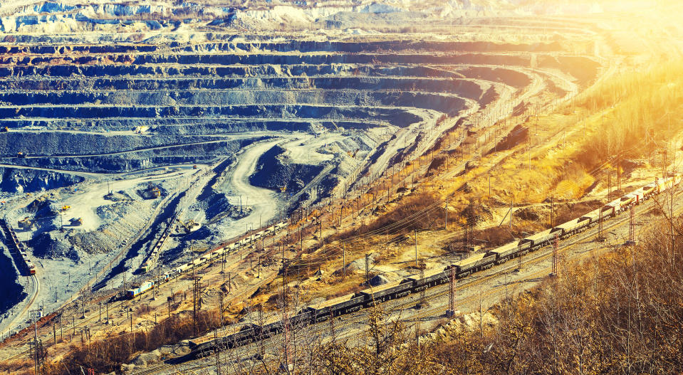 A freight train passing an open mine