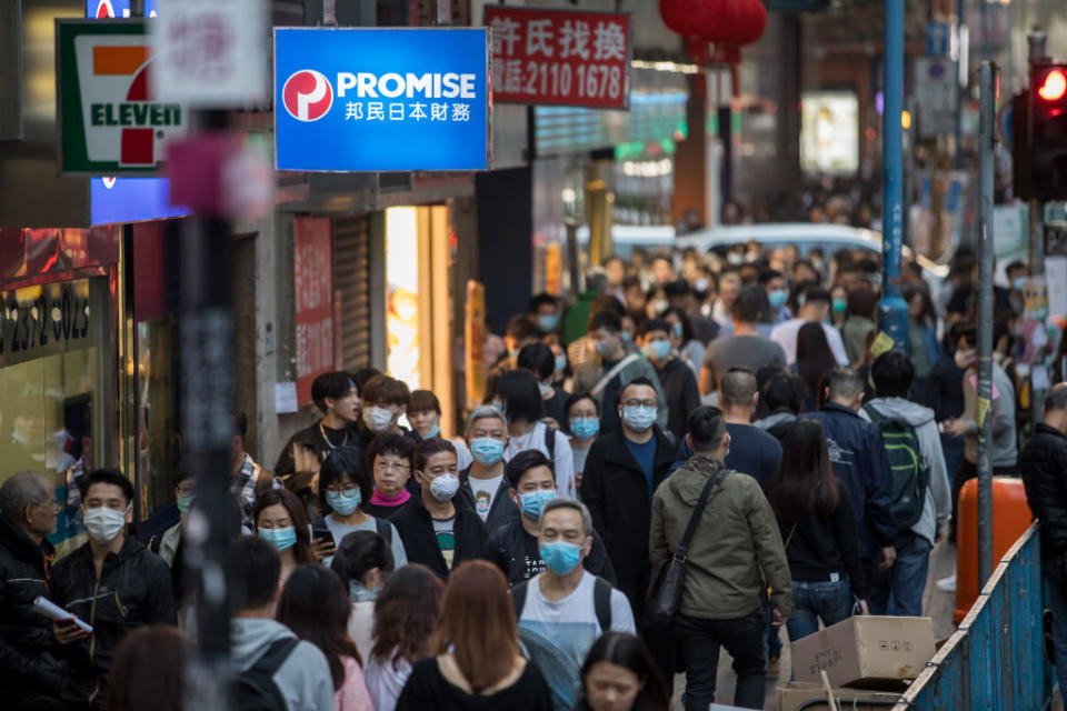 People wearing masks walk on a street in Kwun Tong district of Hong Kong on Jan. 23, 2020. | Paul Yeung–Bloomberg/Getty Images