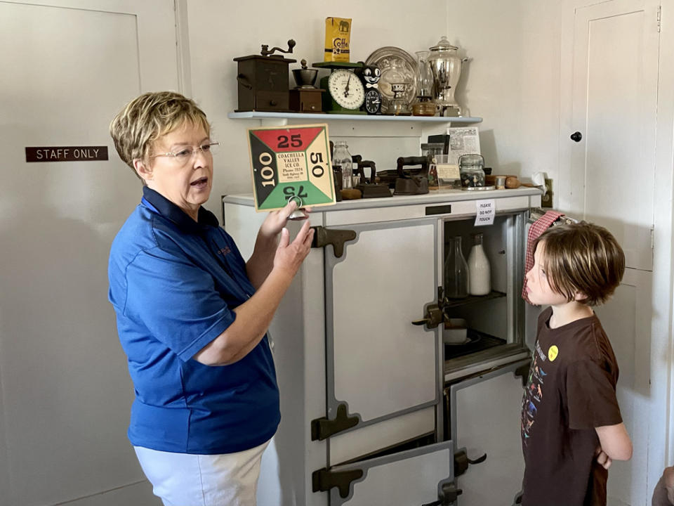 Nine-year-old Jonathan Bastianelli listened as Roberta Jonnet, a docent at the Coachella Valley History Museum, explained how families in the early 1900s used a sign to indicate how much ice they needed for the icebox. (Linda Jacobson/The 74)