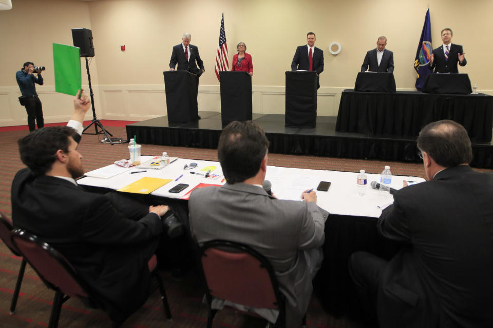 A moderator signals 30-seconds remaining to senate candidate Rep. Roger Marshall, R-Kan., right, during a GOP senatorial debate In Manhattan, Kan., Saturday, May 23, 2020. David Lindstrom, left, Susan Wagle, second from left, Kris Kobach, middle, and Bob Hamilton, second from right, share the debate stage. (AP Photo/Orlin Wagner)