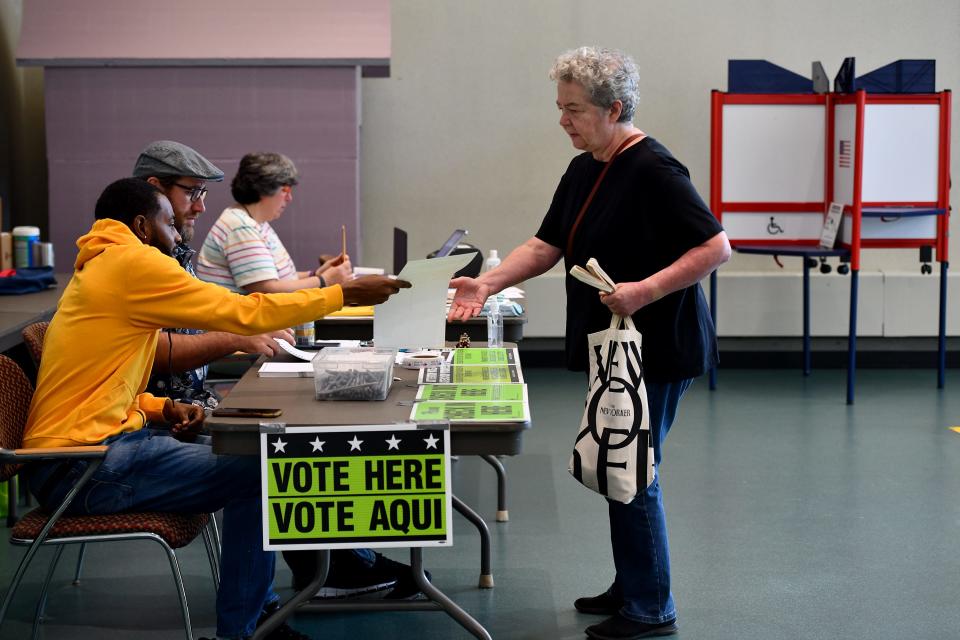 Voter susan Keady receives her ballot at the Worcester Public Library on Tuesday.