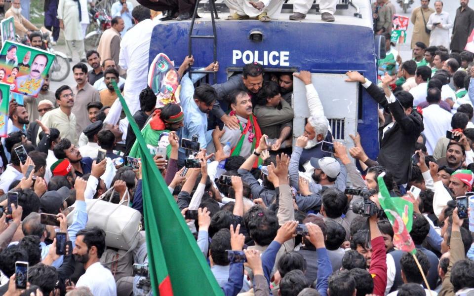 Supporters of opposition political party Pakistan Tehreek-e-Insaf (PTI) react from a police van during a 'Jail Bharo Tehreek' (voluntary court arrest), in Sargodha, Pakistan, 27 February 2023 - ISRAR UL HAQ/EPA-EFE/Shutterstock