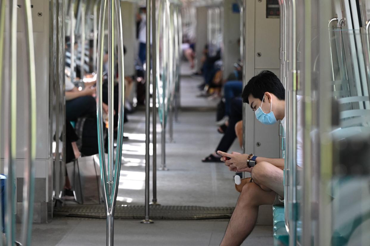 People ride on a mass rapid transit train in Singapore on November 5, 2021. / AFP / Roslan RAHMAN