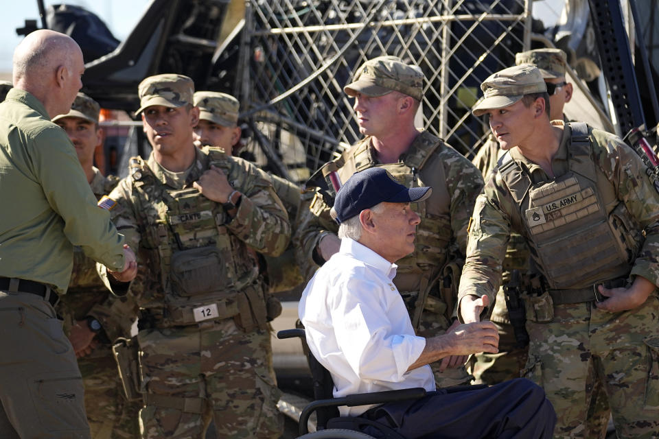 Texas Gov. Greg Abbott, right, and Montana Gov. Greg Gianforte, left, greet members of the National Guard as they arrive with fellow governors for a news conference along the Rio Grande to discuss Operation Lone Star and border concerns, Sunday, Feb. 4, 2024, in Eagle Pass, Texas. Abbott returned to the Eagle Pass border to highlight his escalating attempts to curb illegal crossings on the U.S.-Mexico border. (AP Photo/Eric Gay)