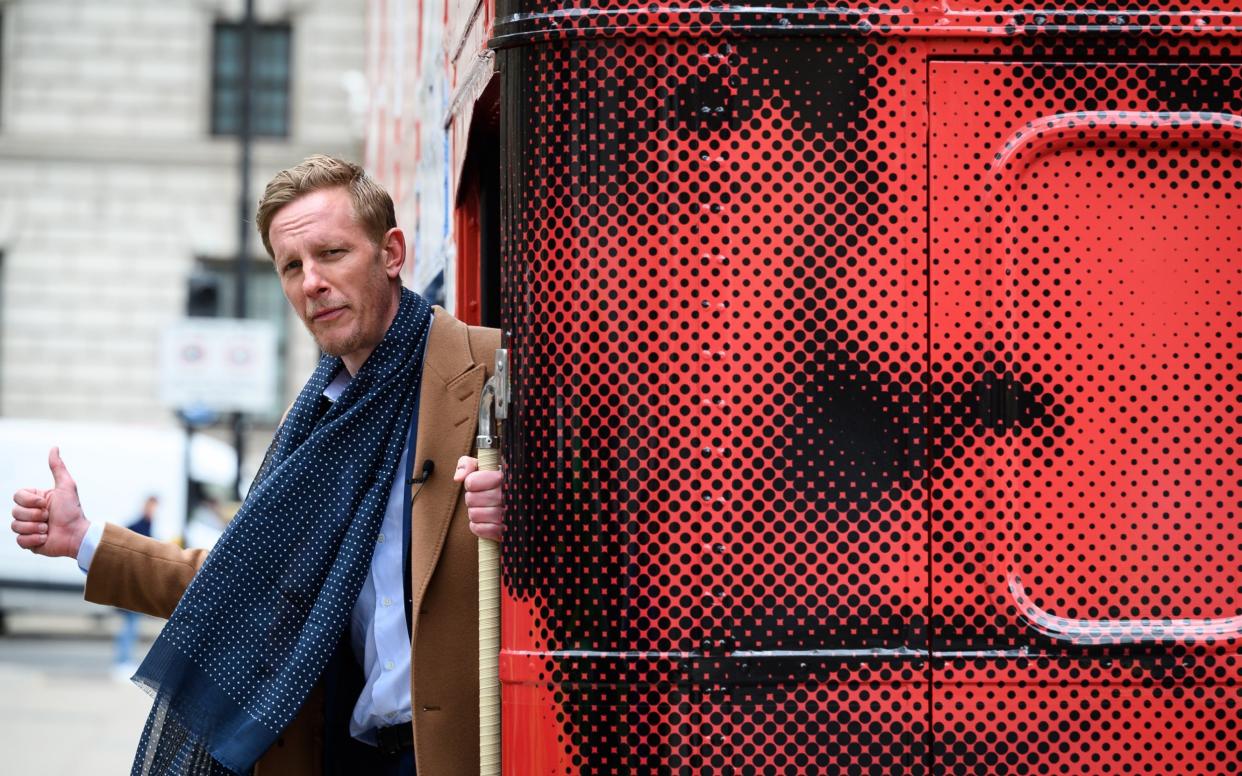 Laurence Fox leans out from the rear of his battle bus after launching his bid to become London Mayor - Leon Neal/Getty