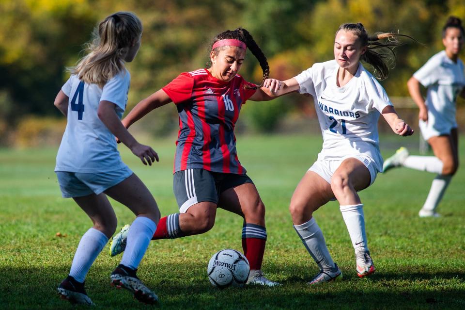 Red Hook's Ani Safaryan, center, kicks the ball through Lourdes defenders during a Section 9 soccer game on Saturday, October 15, 2022.