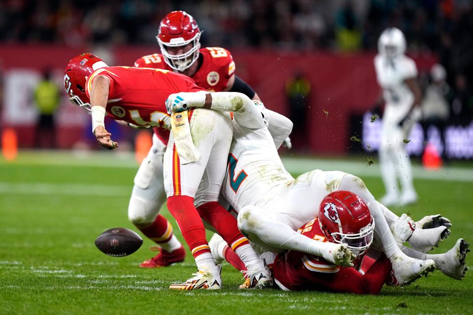 Kansas City Chiefs quarterback Patrick Mahomes, left, fumbles as he is hit by Miami Dolphins linebacker Bradley Chubb (2) during the second half of an NFL football game Sunday, Nov. 5, 2023, in Frankfurt, Germany. The Dolphins recovered the fumble. (AP Photo/Martin Meissner)
