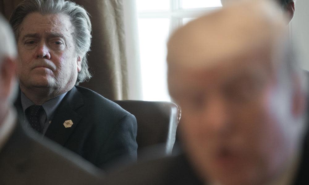 Steve Bannon listens as Donald Trump speaks to the press in the Cabinet Room of the White House.