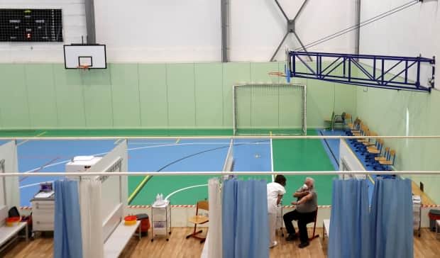A man receives a shot of the COVID-19 vaccine during a trial run of a mass vaccination centre, located inside a gym in the town of Ricany, near Prague, on Feb. 25.