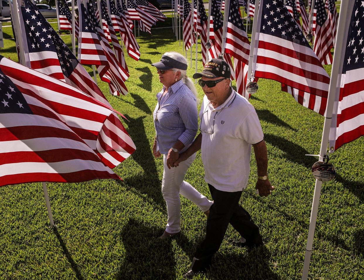 Joan Sargent and her dad, ninety-eight year-old WWII Veteran Bill Nacinovich, walk through a field of flags during the inaugural Flags for Heroes charity event at Bradley Park in 2019. This year's event begins Monday.