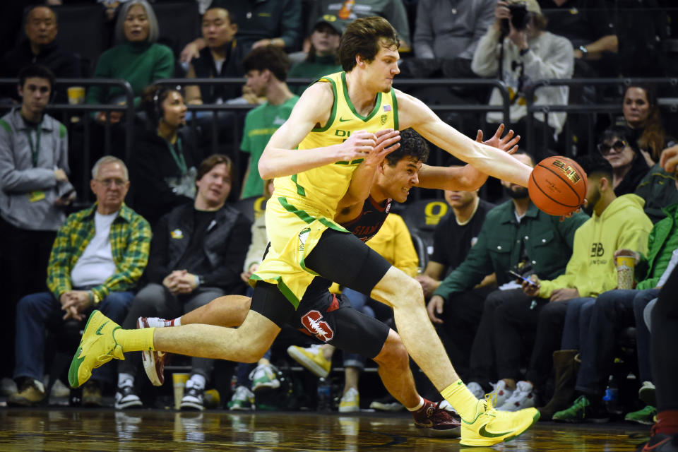 Oregon center Nate Bittle (32) and Stanford forward Brandon Angel (23) battle for a loose ball during the second half of an NCAA college basketball game Saturday, March 4, 2023, in Eugene, Ore. (AP Photo/Andy Nelson)