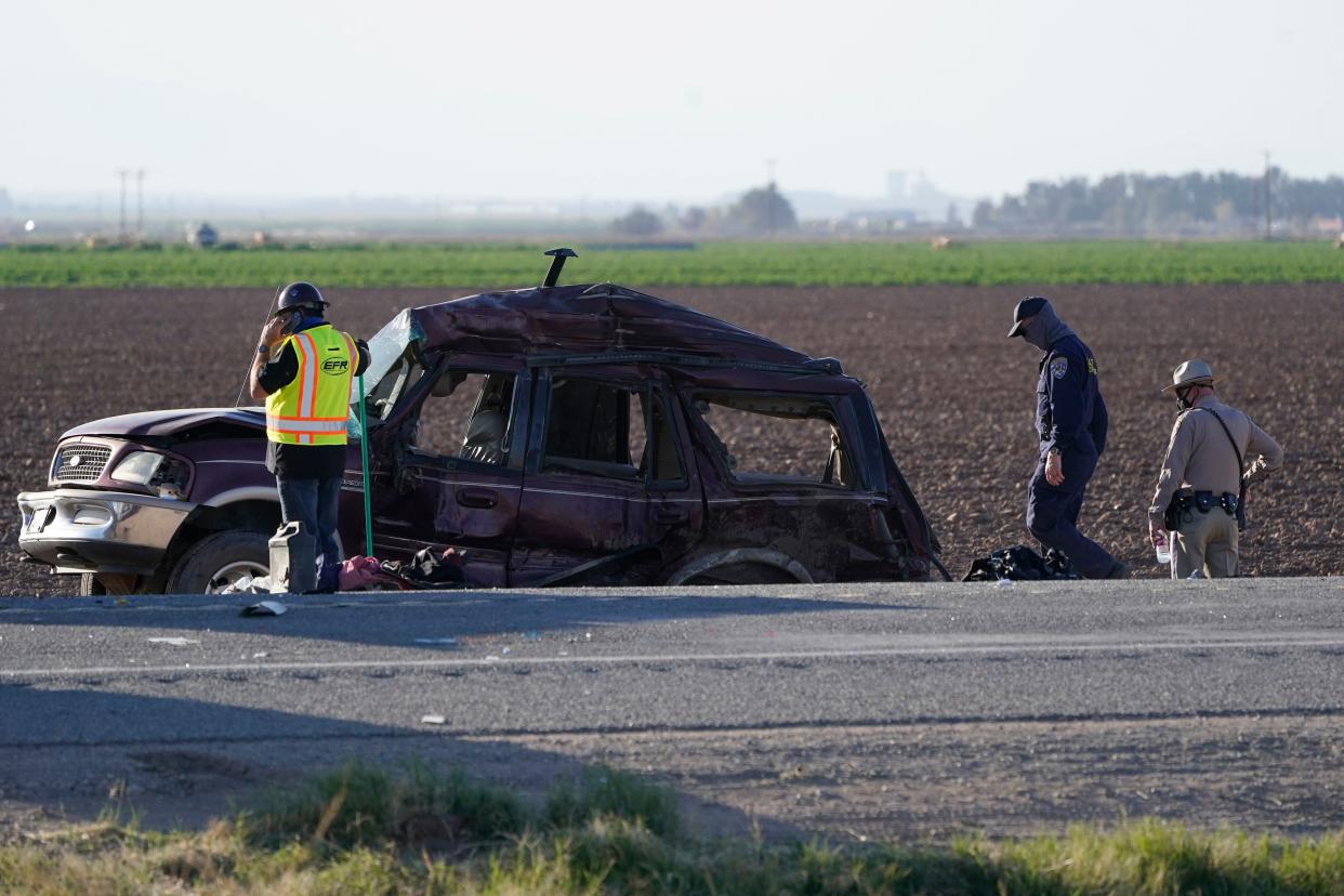 Law enforcement officers sort evidence and debris at the scene of a deadly crash in Holtville, Calif. on Tuesday, March 2, 2021.