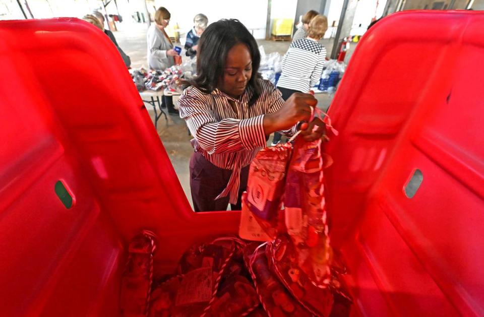 Yolanda Brown, a member of the Salvation Army’s Women’s Auxiliary, places gift filled stockings into a carrier.