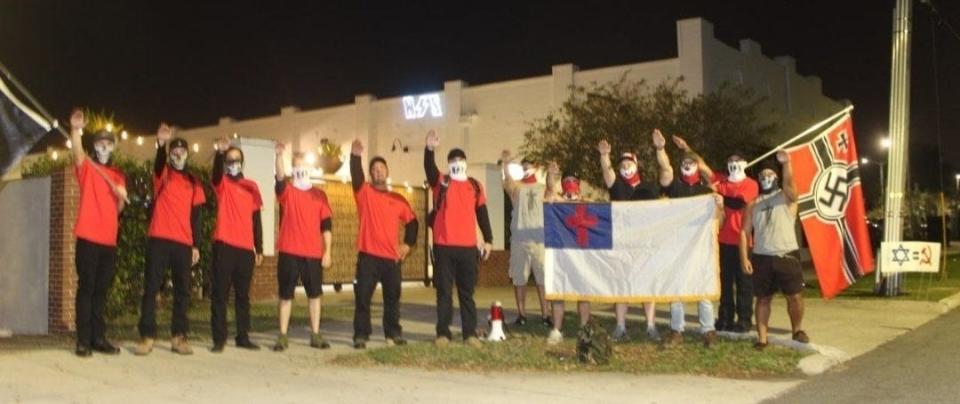 A group holding Nazi flags engages in a Nazi salute Saturday night outside ART/Ifacts Studio in Lakeland. The group demonstrated outside an event that included drag performances.
