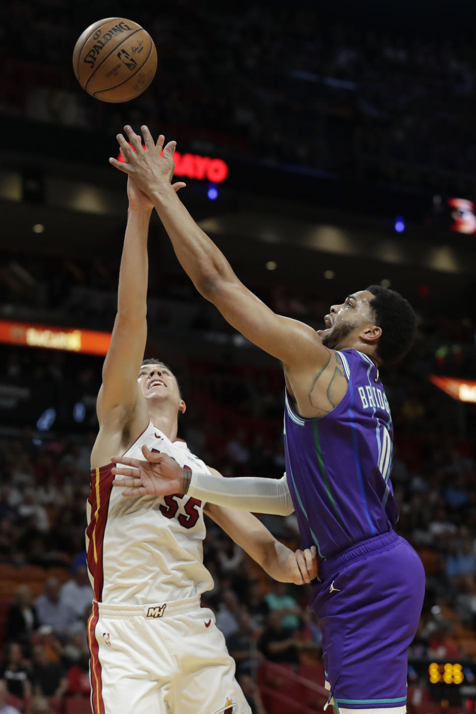 Charlotte Hornets forward Miles Bridges, right, goes up for a shot against Miami Heat forward Duncan Robinson (55) during the first half of an NBA basketball game, Wednesday, March 11, 2020, in Miami. (AP Photo/Wilfredo Lee)