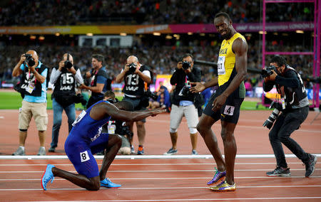 Justin Gatlin of the U.S. kneels down in front of Usain Bolt of Jamaica after the final of the Men's 100 Metres final during the World Athletics Championships at London Stadium, August 5. REUTERS/Phil Noble
