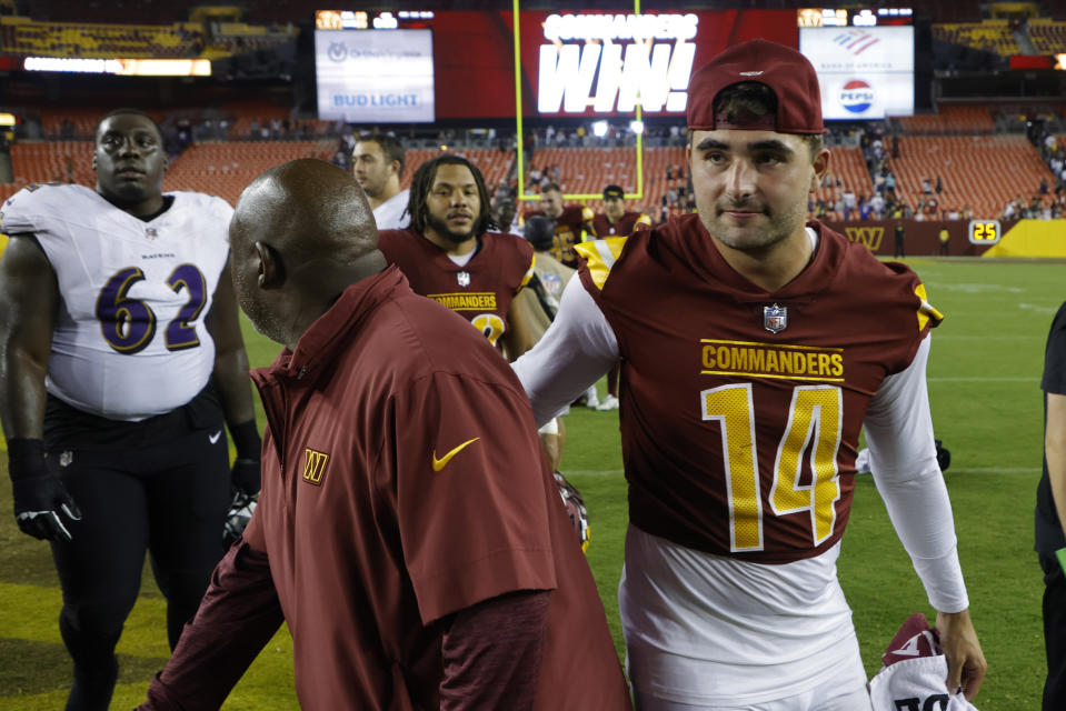 Washington Commanders assistant head coach/offensive coordinator Eric Bieniemy (L) celebrates with Commanders quarterback Sam Howell (14). Mandatory Credit: Geoff Burke-USA TODAY Sports