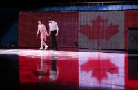 Tessa Virtue and Scott Moir of Canada step onto the ice before their performance for the figure skating exhibition gala at the Iceberg Skating Palace during the 2014 Winter Olympics, Saturday, Feb. 22, 2014, in Sochi, Russia. (AP Photo/Ivan Sekretarev)