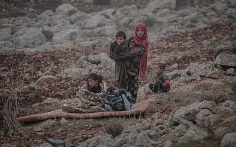 Syrians are seen with their belongings who have been forced to displace due to the ongoing attacks carried out by Assad regime and Russia, during winter season at makeshift tent area in Harbanos town of Idlib, Syria  - Credit: Anadolu