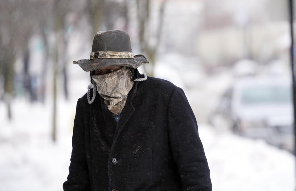 Marvin Hooks wears a face mask to protect him from the cold as he walks on North Street in Pittsfield, Mass., Monday, Jan. 21, 2019. Bitter cold and gusty winds swept across the eastern U.S. Monday with falling temperatures replacing the weekend's falling snow. (Ben Garver/The Berkshire Eagle via AP)