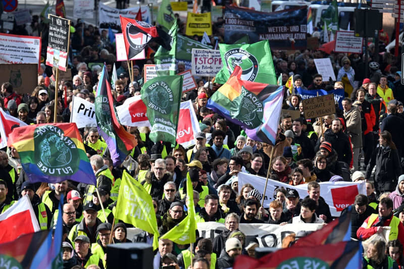Demonstrators march through the city with flags and banners. Much of Germany's public transport will remain out of service on Friday, as the second round of warning strikes by the trade union Verdi climaxes. Federico Gambarini/dpa