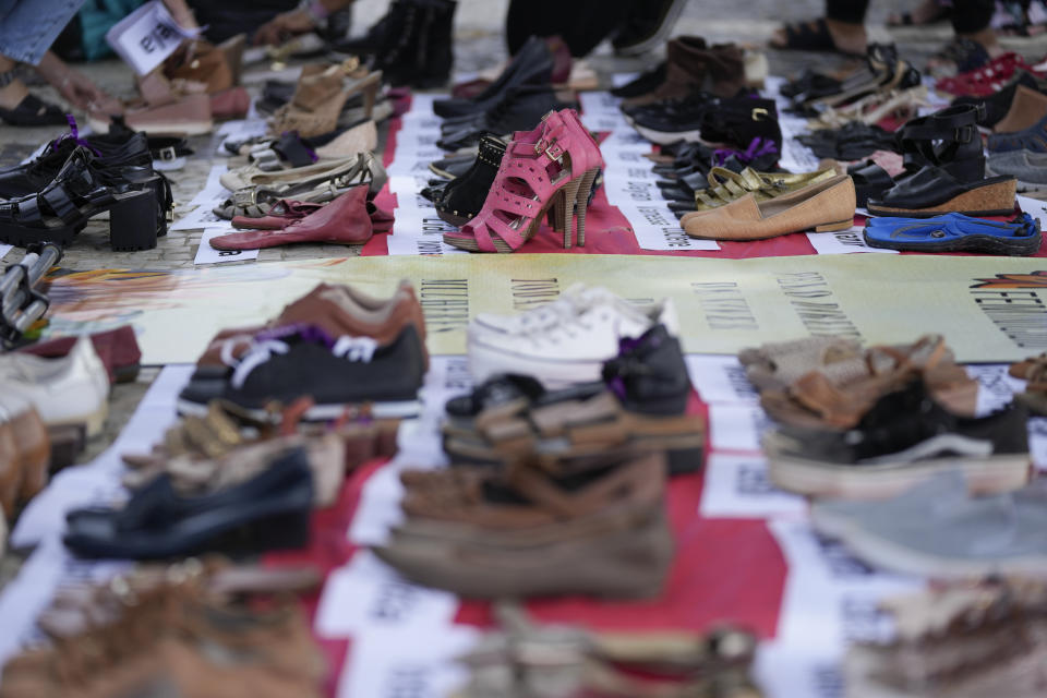 Los nombres de las víctimas de la violencia de género y zapatos de mujer donados se muestran en el borde de la playa de Copacabana para conmemorar el Día Internacional de la Eliminación de la Violencia contra la Mujer, en Río de Janeiro, Brasil, el sábado 25 de noviembre de 2023. (Foto AP/ Silvia Izquierdo)