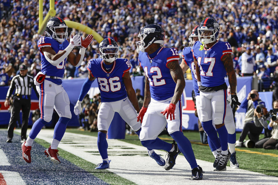 New York Giants tight end Darren Waller (12) celebrates with teammates after scoring a touchdown against the Washington Commanders during the second quarter of an NFL football game, Sunday, Oct. 22, 2023, in East Rutherford, N.J. (AP Photo/Adam Hunger)