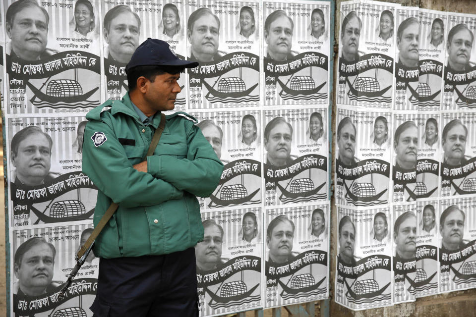 A Bangladeshi policeman stands guard outside a polling station in Dhaka, Bangladesh, Sunday, Jan. 5, 2014. Police in Bangladesh fired at protesters and more than 100 polling stations were torched in Sunday’s general elections marred by violence and a boycott by the opposition, which dismissed the polls as a farce. (AP Photo/Rajesh Kumar Singh)