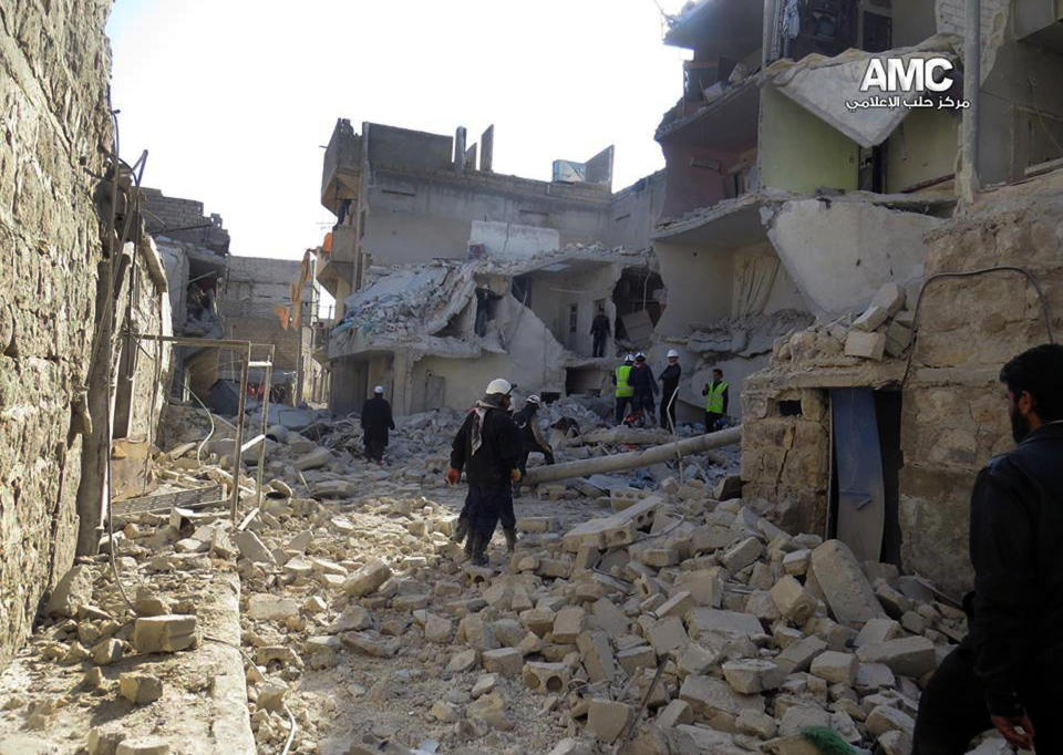 This citizen journalism image provided by Aleppo Media Center (AMC), an anti-Bashar Assad activist group which has been authenticated based on its contents and other AP reporting, shows Syrian rescue workers check the rubble of a destroyed building which was attacked by Syrian forces warplanes, in Aleppo, Syria, Tuesday, Jan. 21, 2014. (AP Photo/Aleppo Media Center, AMC)