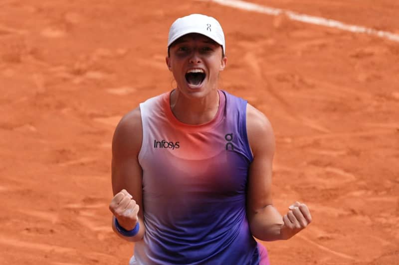 Polish tennis player Iga Swiatek celebrates her victory over Italy's Jasmine Paolini after their women's singles final match of the French Open tennis tournament at the Roland Garros Complex. Dimitar Dilkoff/AFP/dpa