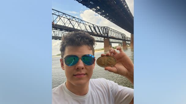 PHOTO: Riley Bryant holds the freshly recovered union US cartridge box plate below the I55 bridge in Memphis, Tenn. (Courtesy Riley Bryant)