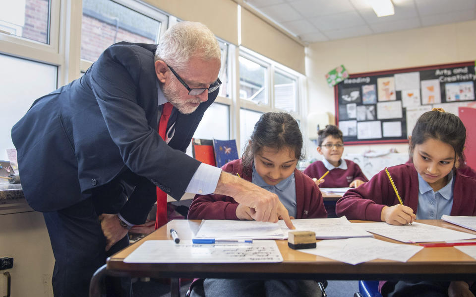 Labour leader Jeremy Corbyn talks to a student during a visit to Fulbridge Academy while on the General Election campaign trail, in Peterborough, England, Thursday, Dec. 5, 2019. Britain goes to the polls on Dec. 12. (Joe Giddens/PA via AP)