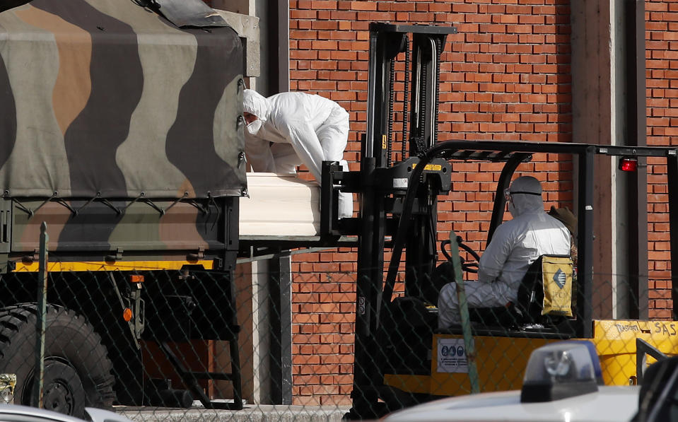 FILE - In this March 28, 2020 file photo, a coffin is loaded onto a military truck to be taken with several others to crematoriums in Venice and Udine, from the San Giuseppe church in Seriate, near Bergamo, northern Italy. Italy is poised to reclaim the dishonor of reporting the most coronavirus deaths in Europe, as the second surge ravages the country’s disproportionately old population and exposes how public health shortfalls and delayed restrictions compounded a lack of preparedness going into the pandemic. (AP Photo/Antonio Calanni, file)