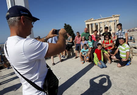 A group of tourists pose for a picture in front of the temple of the Parthenon atop the Acropolis in Athens, Greece, July 2, 2015. REUTERS/Jean-Paul Pelissier