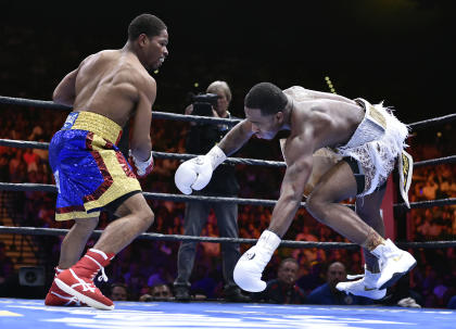 Shawn Porter (L) knocks Adrien Broner off-balance during their fight Saturday. (AP)