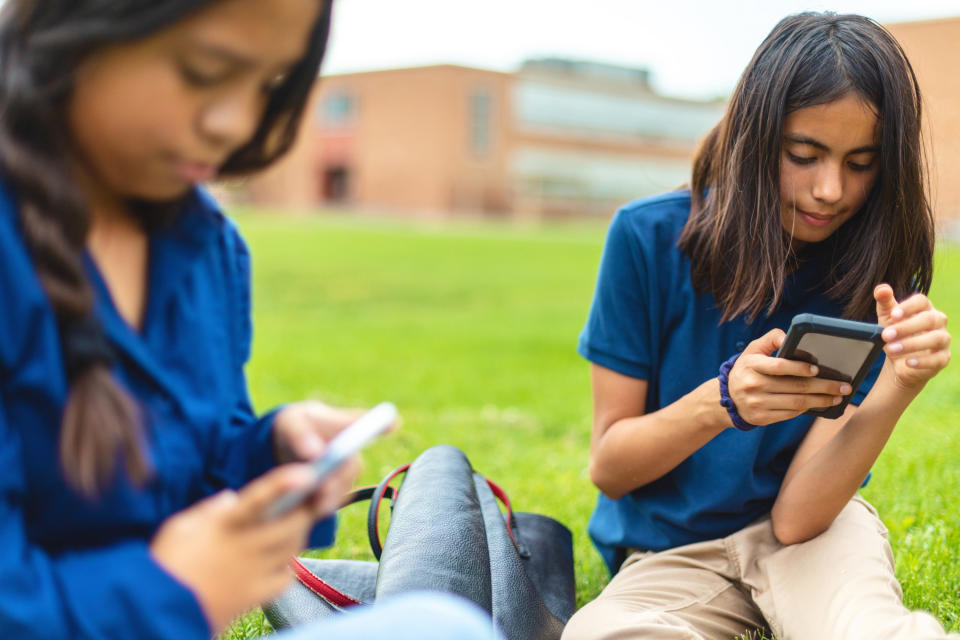 Two teen girls on their phones