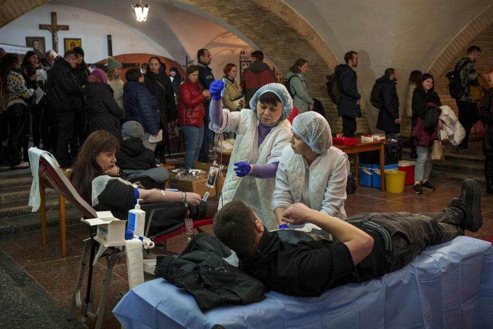 People wait in line to donate blood for wounded Ukrainian personnel, during an event in the basement of the St. Nicholas Roman Catholic Church, in Kyiv, Ukraine, Tuesday, March 19, 2024. (AP Photo/Vadim Ghirda)