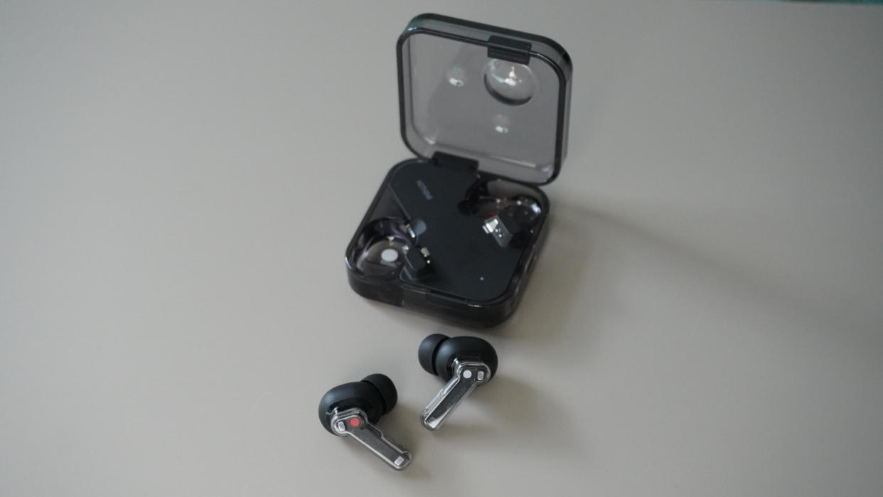  The Nothing Ear wireless earbuds in black on a grey background. 