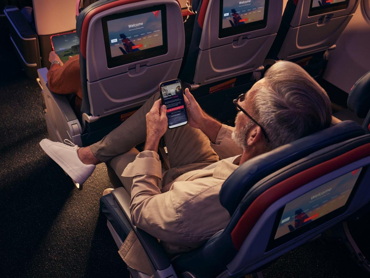 Delta Air Lines passenger looking at his phone with free Wi-Fi.