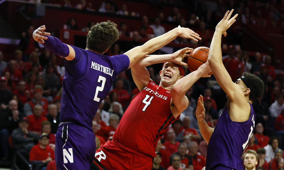 Rutgers guard Paul Mulcahy (4) drives to the basket against Northwestern forward Nick Martinelli (2) and forward Tydus Verhoeven, right, during the second half of an NCAA college basketball game, Sunday, March 5, 2023, in Piscataway, N.J. Northwestern won 65-53. (AP Photo/Noah K. Murray)