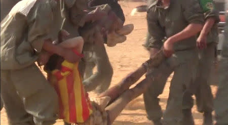 Soldiers carry an injured comrade to an ambulance after a suicide car bomb attack on a military camp in Gao, Mali January 18, 2017 in this still image taken from video. REUTERS/via Reuters TV