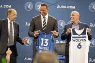 New Minnesota Timberwolves owners Marc Lore, right, and baseball great Alex Rodriguez, center, hold jerseys presented to them by team owner Glen Taylor during a new conference to introduce the new ownership partners of the NBA Timberwolves basketball team and the Minnesota Lynx of the WNBA, Monday, Sept. 27, 2021, in Minneapolis. (AP Photo/Jim Mone)