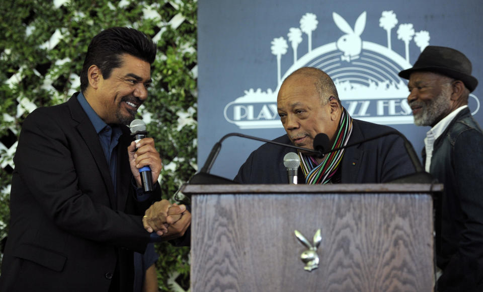 Musician Quincy Jones, center, joins hands with new Playboy Jazz Festival master of ceremonies George Lopez, left, at a news conference at the Playboy Mansion on Thursday, Feb. 28, 2013 in Los Angeles. Looking on at right is jazz musician Hubert Laws. The 35th Anniversary Playboy Jazz Festival will be held at the Hollywood Bowl on June 15 and 16. (Photo by Chris Pizzello/Invision/AP)