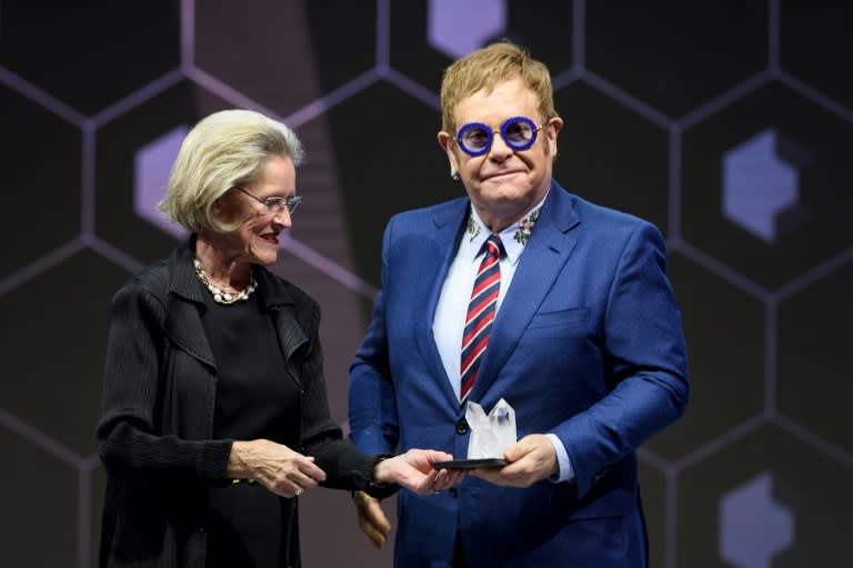 Elton John receives an award in Davos, for his campaigning work on AIDS, from Hilda Schwab, co-founder of the Schwab Foundation for Social Entrepreneurship