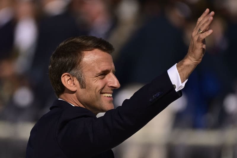 French President Emmanuel Macron waves during an international ceremony on Omaha Beach, as part of the commemoration of the 80th anniversary of the Normandy landings, in Saint-Laurent-sur-Mer, France.  Dirk Waem/Belgian/dpa