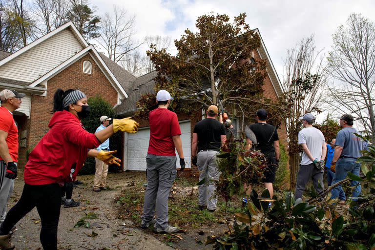 Vecinos retiran un árbol y escombros de la casa de Ken Jannot (que no aparece en la fotografía)
