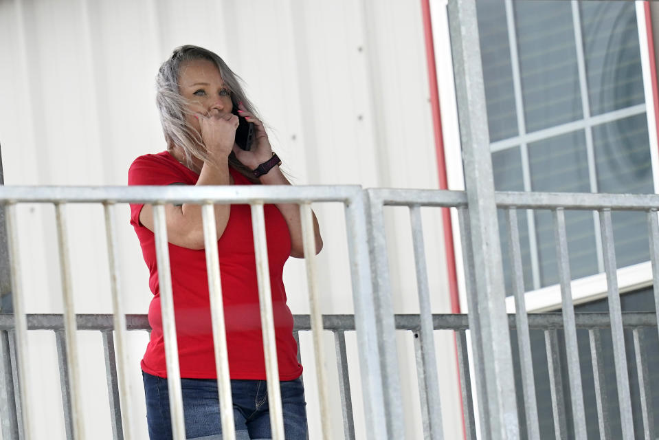 Marion Cuyler, fiancée of missing crew member Chaz Morales, talks on her cell phone at a fire station where family members of 12 people missing from a capsized oil industry vessel have been gathering, Thursday, April 15, 2021, in Port Fourchon, La. The lift boat capsized in the Gulf of Mexico during a storm on Tuesday, killing one with 12 others still missing. (AP Photo/Gerald Herbert)