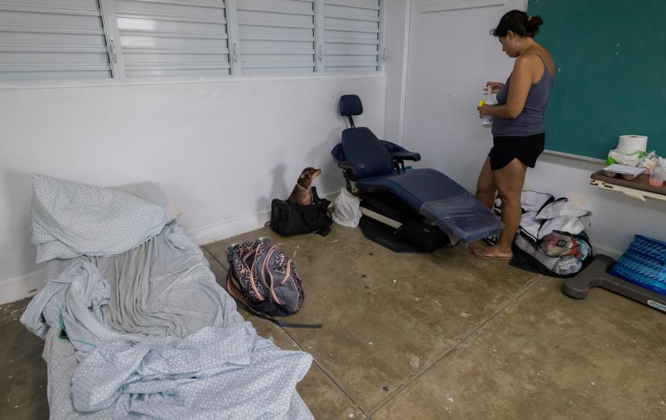 A woman and her dog take refuge in a shelter from Hurricane Fiona in Loiza, Puerto Rico, Sunday, Sept. 18, 2022.