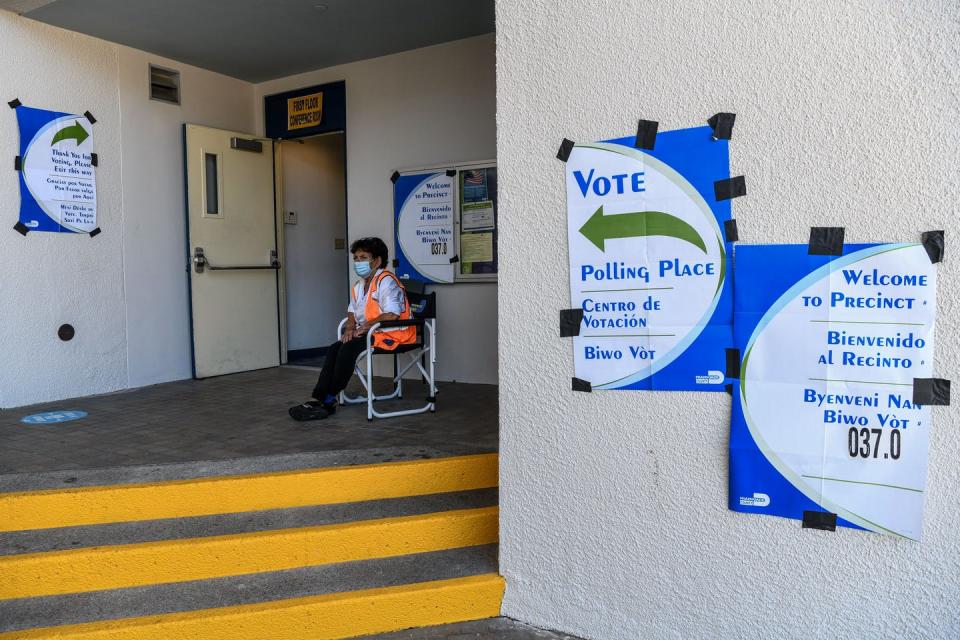 A masked poll worker outside a polling center.