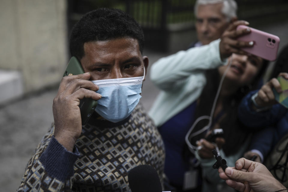 Manuel Ranoque, the father of two of the youngest Indigenous children who survived an Amazon plane crash that killed three adults, and then braved the jungle for 40 days before being found alive, speaks on a mobile phone from the entrance of the military hospital where the children are receiving medical attention, in Bogota, Colombia, Sunday, June 11, 2023. (AP Photo/Ivan Valencia)